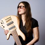 woman holding up bass guitar