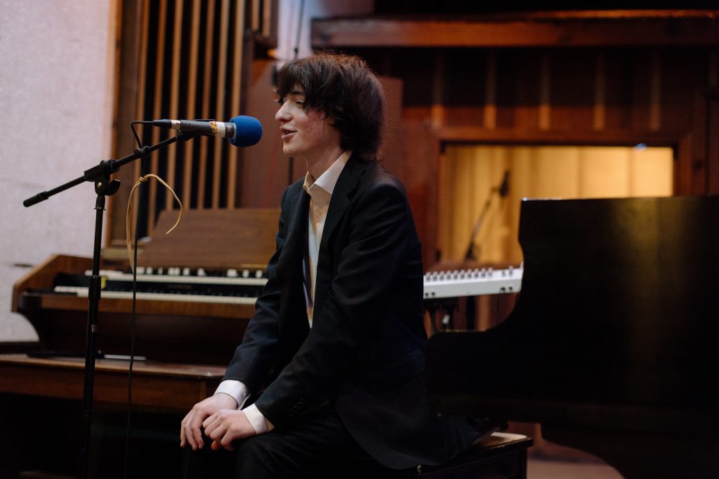 boy at microphone in front of piano